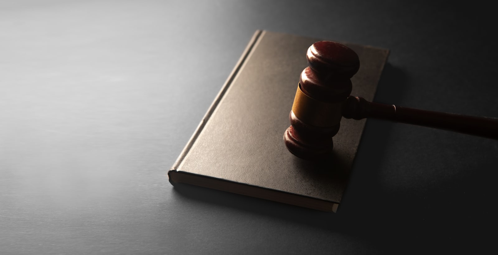 Wooden gavel resting on a closed book